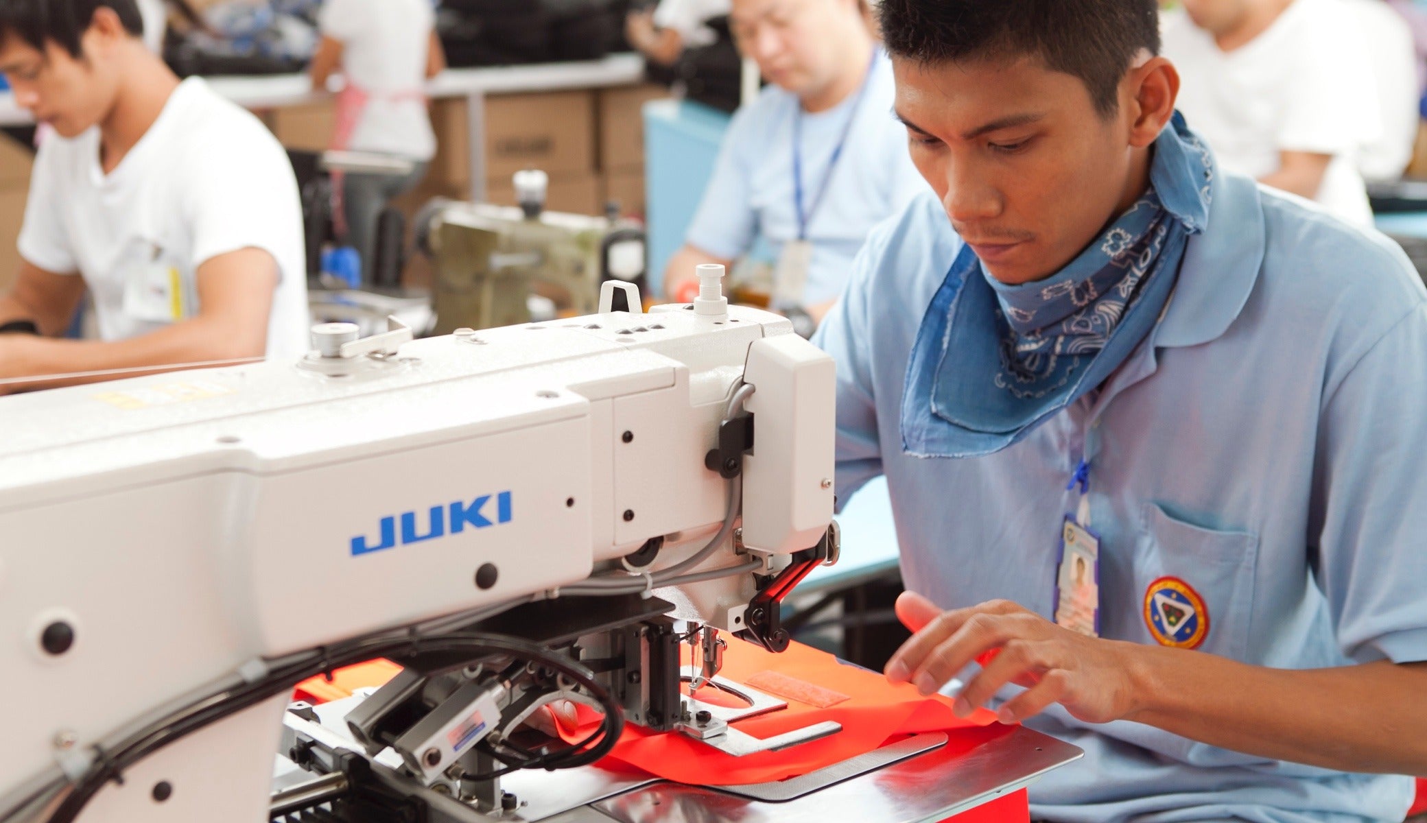 A factory worker sews a Del Día pack.