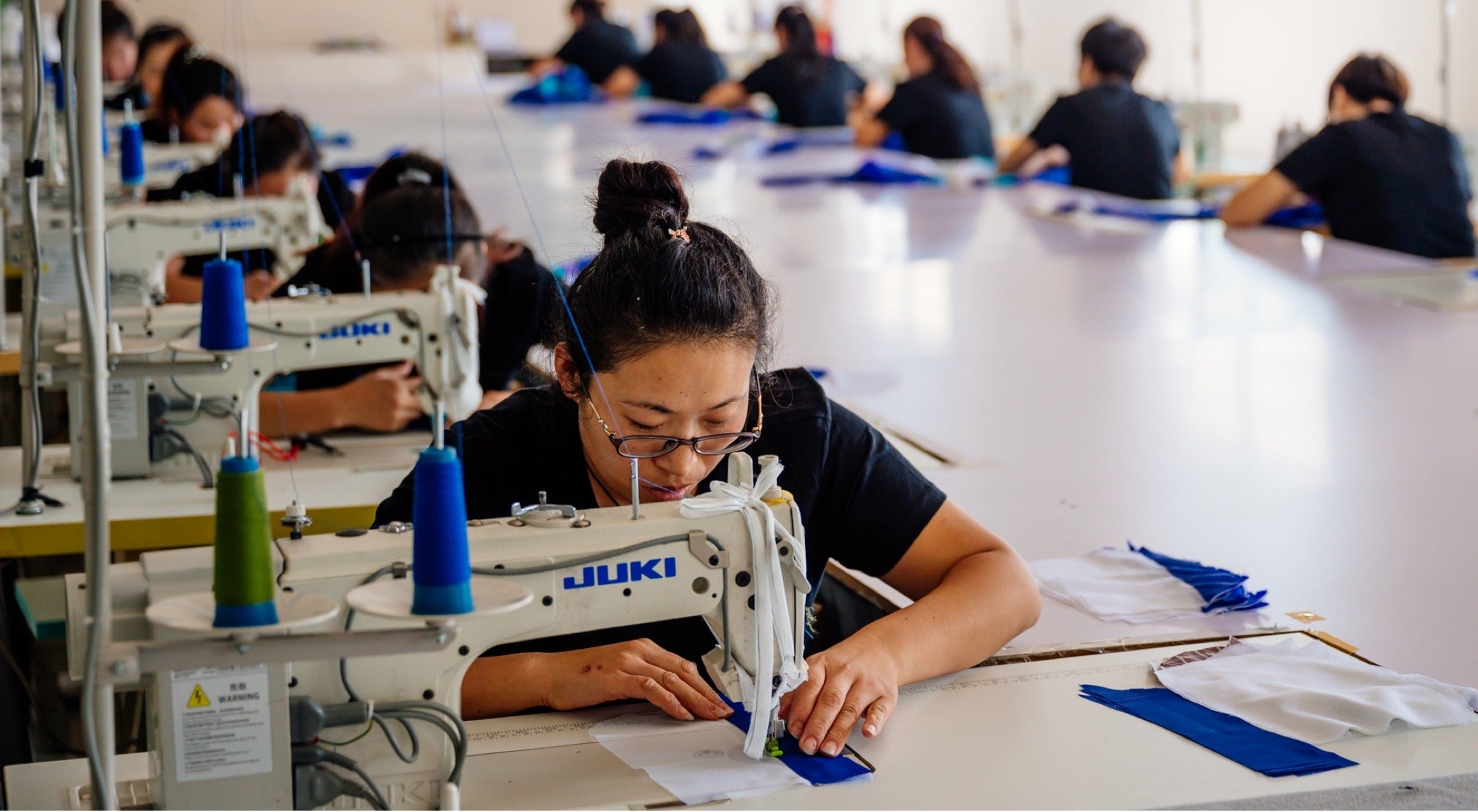 Sewer Mu Li Fang works on the Cotopaxi Teca line